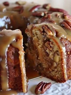 a close up of a cake on a plate with pecans and caramel drizzle