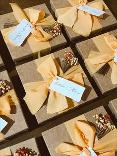 several boxes with different types of flowers and ribbons tied to each other on the table