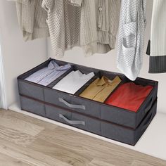 an open suitcase with clothes hanging from it's sides in front of a closet