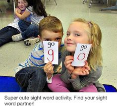 two children sitting on the floor holding up their numbers