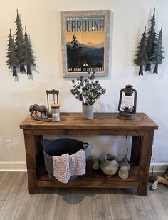 a wooden table topped with vases filled with flowers next to a sign that says welcome to carolina