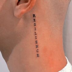 a woman's neck with the word resilience written on it and behind her ear