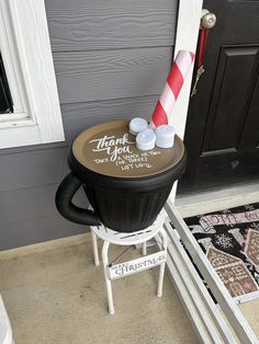 a candy cane sitting on top of a black chair in front of a gray door