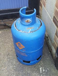 a blue propane tank sitting in front of a building