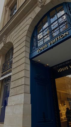 the front entrance to louis vuitton in paris, with blue doors and windows