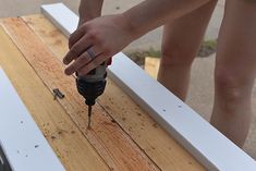 a person using a drill to attach wood planks