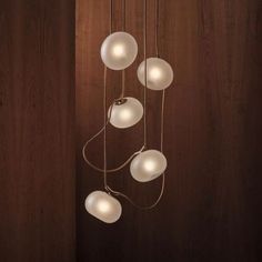 three white lights hanging from a wooden wall