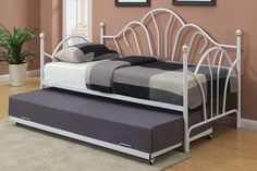 a white day bed with a pull out trundle and mattress on it's side