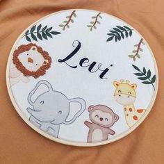 a close up of a embroidery on a piece of cloth with animals and letters that spell out the word leo