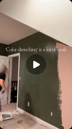 a man is painting the walls in a room that has been painted green and pink