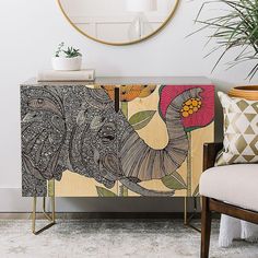 an elephant is painted on the sideboard next to a chair and potted plant