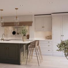 a large kitchen with an island and bar stools next to it, surrounded by white cabinets