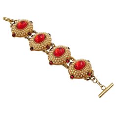 This lovely French Designer Chantal Thomass Paris jeweled link bracelet features gilded-metal carved and domed elements, all paved and ornate with half-pearl-like and ruby-red cabochons. An impressive ruby-red textured resin cabochon embellishes each link in its center. The toggle fastening clasp has the signature engraved: "Chantal Thomass." Each link is signed at the back with the brand logo. The bracelet is in good condition, with minor gilt fading at the back, but it does not significantly a Red Ruby Bracelet, Glamorous Jewelry, Platinum Bracelet, Chantal Thomass, Ruby Bracelet, Gold Link Bracelet, French Jewelry, Antique Bracelets, Bracelet Pearl