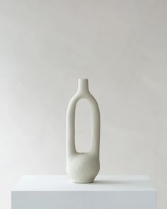 a white vase sitting on top of a table