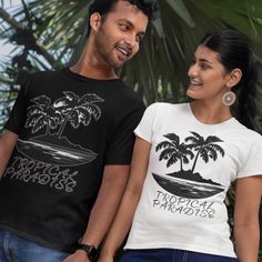 Embrace the beauty of a tropical paradise with our stunning T-shirt featuring an illustration of a tranquil beach scene. Two majestic palm trees are silhouetted by the glowing full moon, creating a sense of serenity and relaxation. This unique and stylish tee is perfect for anyone who loves the allure of tropical destinations. Made from high-quality materials, this shirt is comfortable to wear and sure to turn heads wherever you go. Bring a piece of paradise into your wardrobe with our Tropical Paradise T-shirt. The unisex soft-style t-shirt puts a new spin on casual comfort. Made from very soft materials, this tee is 100% cotton for solid colors. Heather colors and sports grey include polyester. The shoulders have twill tape for improved durability. There are no side seams. The collar is Tropical Print T-shirt For Vacation, Tropical Cotton T-shirt With Palm Tree Print, Black Graphic Print T-shirt For Vacation, Tropical Relaxed Fit T-shirt With Palm Tree Print, Tropical Crew Neck T-shirt With Palm Tree Print, Vacation Tropical Printed T-shirt, Tropical Printed T-shirt For Vacation, Beach And Palm Trees, Majestic Palm