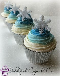 three cupcakes decorated with frosting and snowflakes