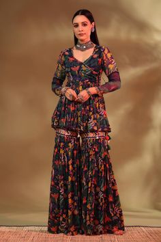 Navy blue angarkha choli style kurta in chiffon base with wildlife pattern, enclosed with dori tassels, embellished with birds and cowries, and panelled full sleeves. It is paired with matching gharara pant.
Components: 2
Pattern: Wildlife
Neckline: V Neck
Sleeve Type: Full
Fabric: Top: Chiffon, Gharara Pant: Modal Satin and Chiffon
Color: Blue
Other Details: 
Length: 
Angarkha top: 28inches
Gharara pant: 40.5inches
Model Height: 5ft 6inches, wearing size XS
Note: The jewellery worn by the model Wedding Outfits Indian, Gharara Pants, Gharara Designs, Amara Dress, Ootd Instagram, Women Kurta, Simple Kurta Designs, Summer Nature, Style Photography