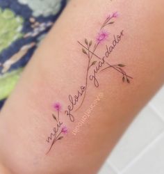 a woman's thigh with the word, love and flowers tattooed on it