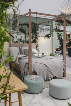 a bedroom with a canopy bed surrounded by potted plants and greenery on the walls