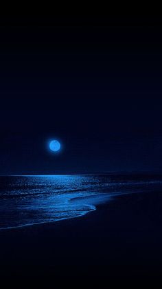 the moon shines brightly in the dark sky over the water at night on the beach