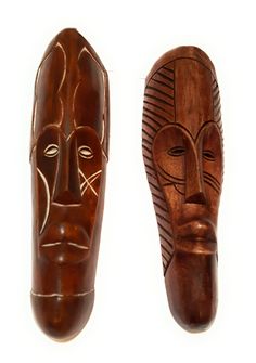 two wooden masks sitting next to each other