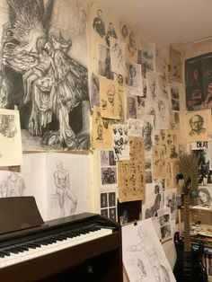 a piano in front of a wall covered with pictures and drawings on it's walls