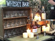 bottles and glasses are on display with candles