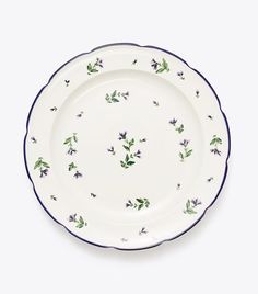 a white plate with blue trim and purple flowers on the rim, against a white background