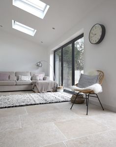 a living room filled with furniture and a skylight