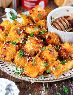 a plate filled with fried food next to a bowl of dipping sauce