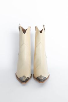 Take your look to the Wild West with the Vannah Western Bootie. This sleek and stylish bootie is the perfect mix of country and sass, featuring a metal toe accent to give you a hint of edge and a chunky heel for a comfy and comfortable fit. Yee-haw! *The off-white is a faux-leather material, the brown is a faux cowhide textured. Both feature an inside zipper for ease of putting them on. These fit true to size and have a 3.5" heel. All sale items are considered final sale. Brown And White Cowgirl Boots, Western Cream Ankle Boots, Western Cream Pointed Toe Heeled Boots, Brown Western Booties With Snip Toe, Brown Leather Western Booties, Cream Colored Boots, Country Shoes, Faux Cowhide, Heart Shoes