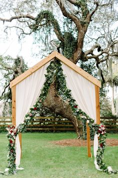 an outdoor wedding setup with white drapes and greenery