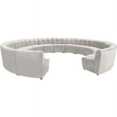 the curved couch is white and has four chairs around it, both facing each other