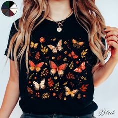 Autumnal Butterflies Unisex Cottagecore Tee Shirt | Butterfly Shirt | Boho Tee | Cottagecore Clothing  ✔️ Soft, light and comfortable unisex short sleeve tee ✔️ 100% Airlume combed and ringspun cotton (fiber content may vary for different colours*) ✔️ Light fabric (4.2 oz/yd² (142 g/m ✔️ Retail fit 📏 Runs true to size ✔️ Dual side seams for structural support of the garment help hold its shape longer ✔️ Ribbed knit elastic collars to bolster shaping, twill taped shoulders to prevent stretching Multicolor Crew Neck Top With Butterfly Print, Casual Black Tops With Butterfly Print, Casual Black Top With Butterfly Print, Black Cotton T-shirt With Butterfly Print, Multicolor Short Sleeve T-shirt With Butterfly Print, Multicolor Casual T-shirt With Butterfly Print, Spring Black T-shirt With Custom Print, Casual Multicolor Butterfly Print T-shirt, Cotton Multicolor Tops With Butterfly Print