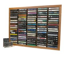 a wall mounted cd rack with many different types of cds and cassettes on it