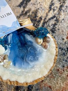 a blue and white shell with shells in it sitting on a table next to a card