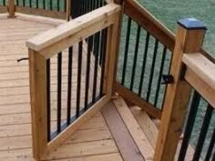 a wooden deck with black iron railings