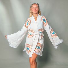 "Stay trendy and comfortable with the Evil Eye Kaftan Kimono. Made from 100% organic cotton and hand-printed with the timeless evil eye design, this Greek goddess-style kaftan is the perfect cover-up for all your summer needs.  Whether you're spending the day at the beach, picnicking in the park, or just lounging at home, the lightweight, breathable fabric will keep you cool and comfortable, and protect you from evil spirits and evil eyes. This eco-friendly and quick-drying kimono is an excellent choice for summer activities. Features *100% Cotton  *Soft, Light & Fluffy *An adjustable waist belt secures the robe from the front. Size: Length: 35.5\" - 90cm     Width: 33.5\" - 85 cm Model Height :5′ 2\"- 160 cm Care *Machine wash cold at a gentle cycle. *No bleach. *Iron on the reverse side Cotton Long Sleeve Kimono For Fall, Long Sleeve Cotton Kimono For Fall, White Cotton Kimono For Fall, Cotton Open Front Kimono For Fall, Summer Cotton Outerwear With Open Front, White V-neck Beach Outerwear, White V-neck Outerwear For Beach, Fall Cotton Open Front Kimono, Summer Cotton Open Front Outerwear