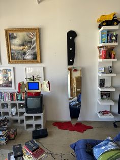 a living room filled with furniture and bookshelves next to a wall mounted tv