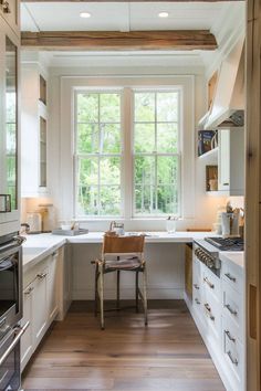 a kitchen with wooden floors and white cabinets