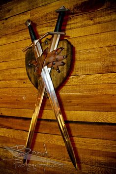 two crossed swords are attached to a heart shaped plaque