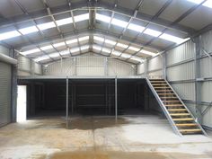 an empty garage with stairs leading up to the second floor and storage doors on both sides