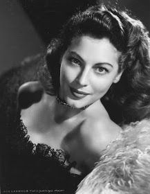 an old black and white photo of a woman wearing a fur stole over her shoulder