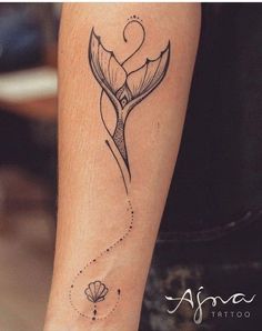 a small tattoo on the arm of a woman with a mermaid tail and starfish