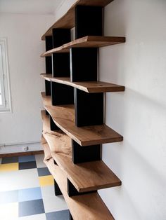 a wooden shelf sitting on the side of a wall next to a checkered floor