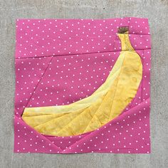 a piece of fabric with a banana on it sitting on top of a cement floor