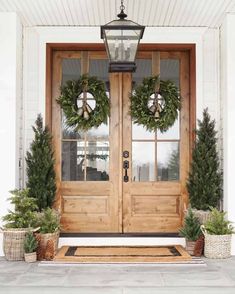 two wreaths on the front door of a house