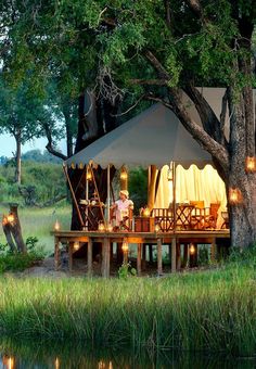 a tent is set up in the middle of a field with candles lit on it