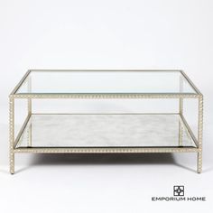 Our Stud Coffee Table brings the artistry of hand cast iron to a new level with a unique and on trend design element. Tiny pyramid studs line the entire frame of this design, all gleaming with a hand gilded silver leaf finish. Topped off with a clear glass top and an antique beveled mirror shelf, this table will add the perfect pop of rock and roll chic to any space. Dimensions Overall 44"L x 25"W x 18.5"H (72 lbs)  Table top can hold up to 48 lbs, bottom shelf can hold up to 48 lbs Silver Leaf Mirror Shelf, Candle Wall Decor, Silver Table, Organization Furniture, Mirror With Shelf, Vanity Decor, Leaf Table, Beveled Mirror, Sofa Tables