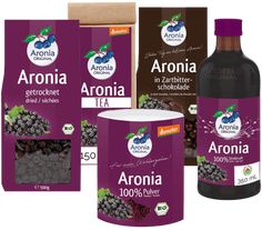 three bottles of aroniaa tea and two packages of blueberries on the side